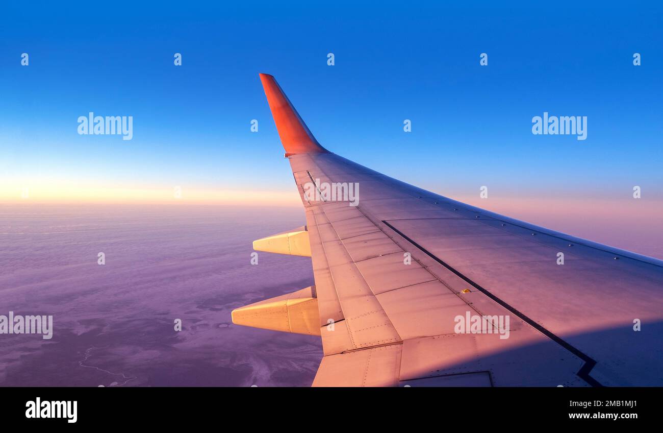 Vista panoramica della cabina attraverso la finestra di un aereo. Volo aereo sopra terra e cielo blu con spazio per il testo Foto Stock