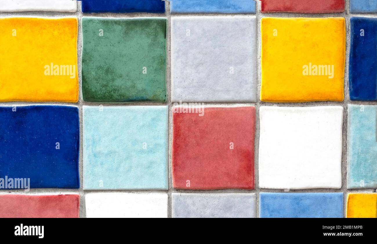 Parete con file di piastrelle colorate quadrate come sfondo Foto Stock