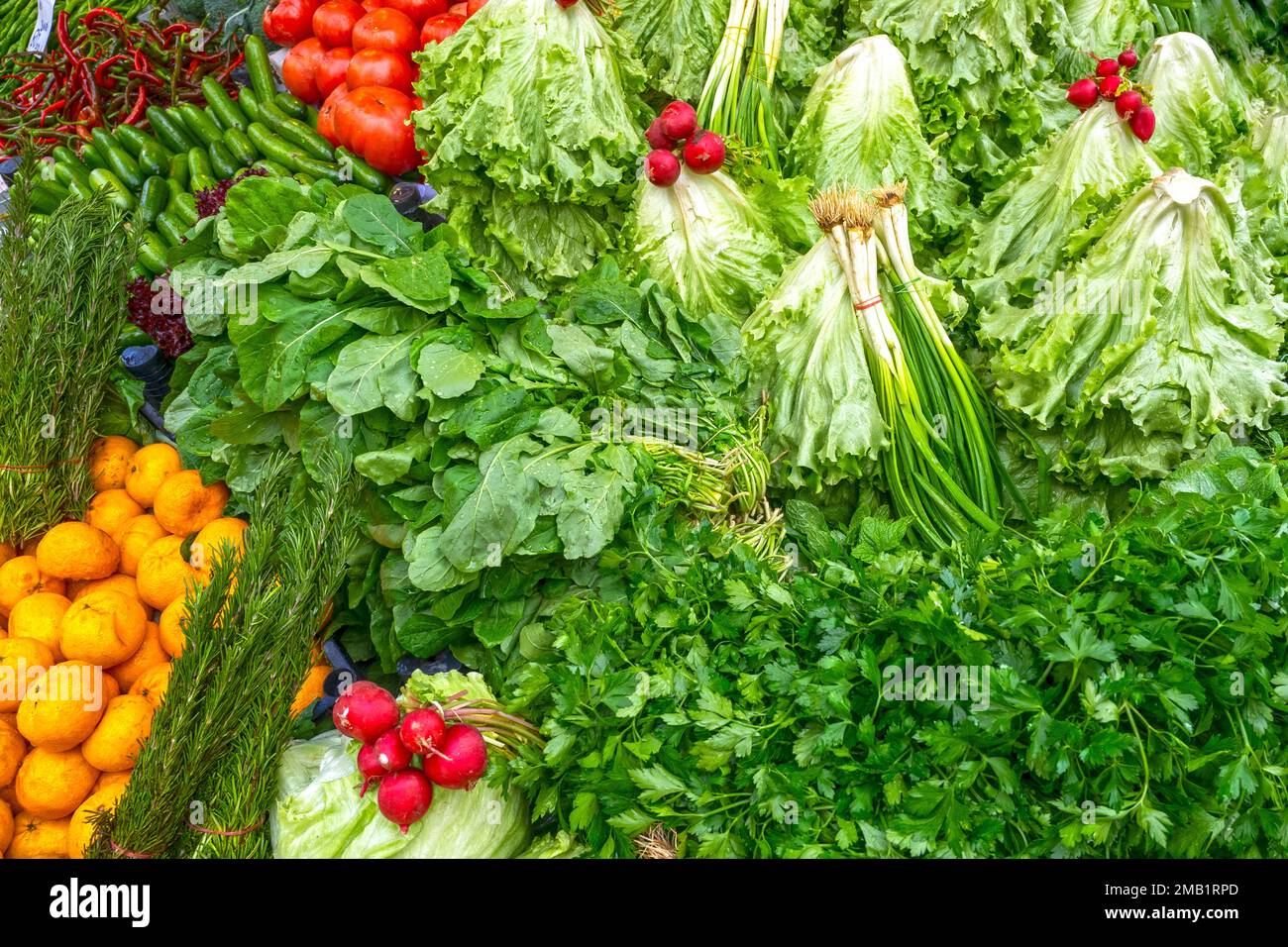 Foglie verdi fresche di insalate, rafano, pomodori, verdure in un mercato di strada in Turchia Foto Stock