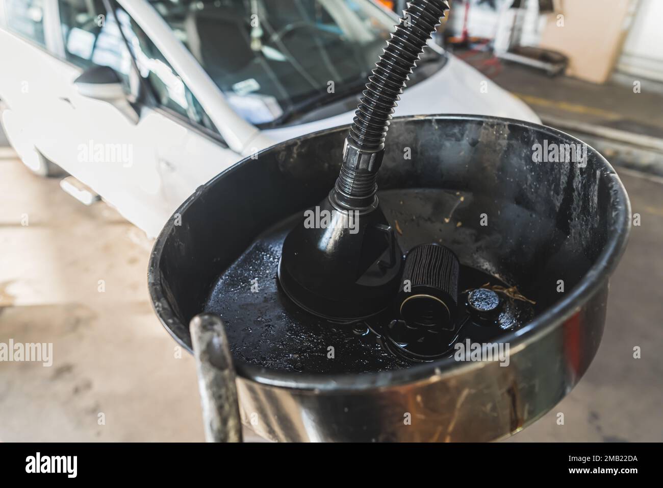 Un filtro dell'olio motore e un contenitore dell'olio recentemente sostituiti in un'officina di riparazione auto. Foto di alta qualità Foto Stock