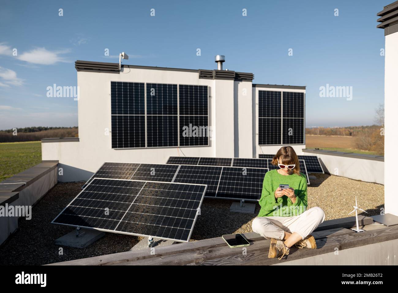 Donna sul tetto della sua casa con una pianta solare Foto Stock