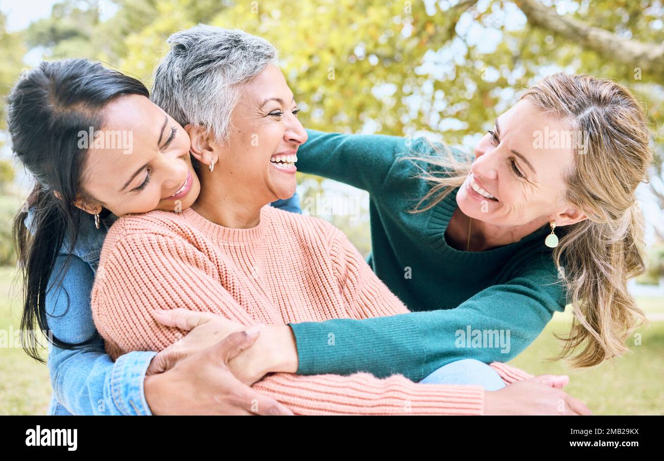 Pensione abbraccio, anziani e donne di legame nel parco naturale, prato o ambiente relax in fiducia, comunità o sicurezza. Sorridere, felice e anziano Foto Stock