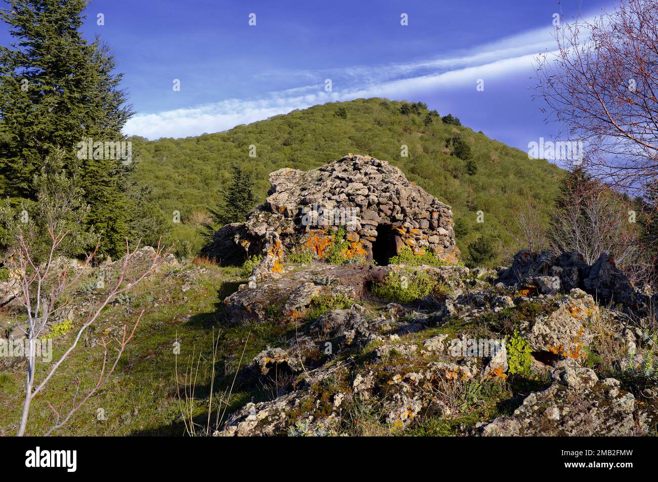 Antico edificio tradizionale di capanna dei pastori con pareti e tetto in pietra a secco in Sicilia, Parco Nazionale dell'Etna, Italia Foto Stock