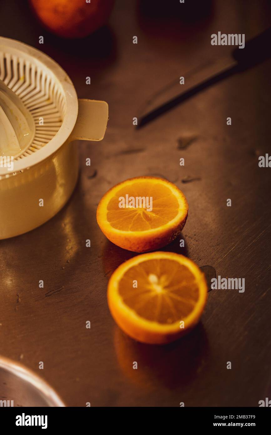 Un primo piano verticale di un limone tagliato a metà su un tavolo di legno in cucina Foto Stock