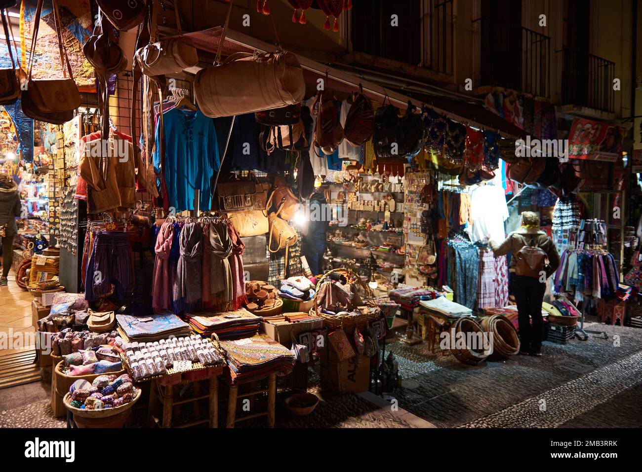 Turisti e negozi di souvenir vendono artigianato marocchino di notte, Granada, Andalusia, Spagna, Europa. Foto Stock