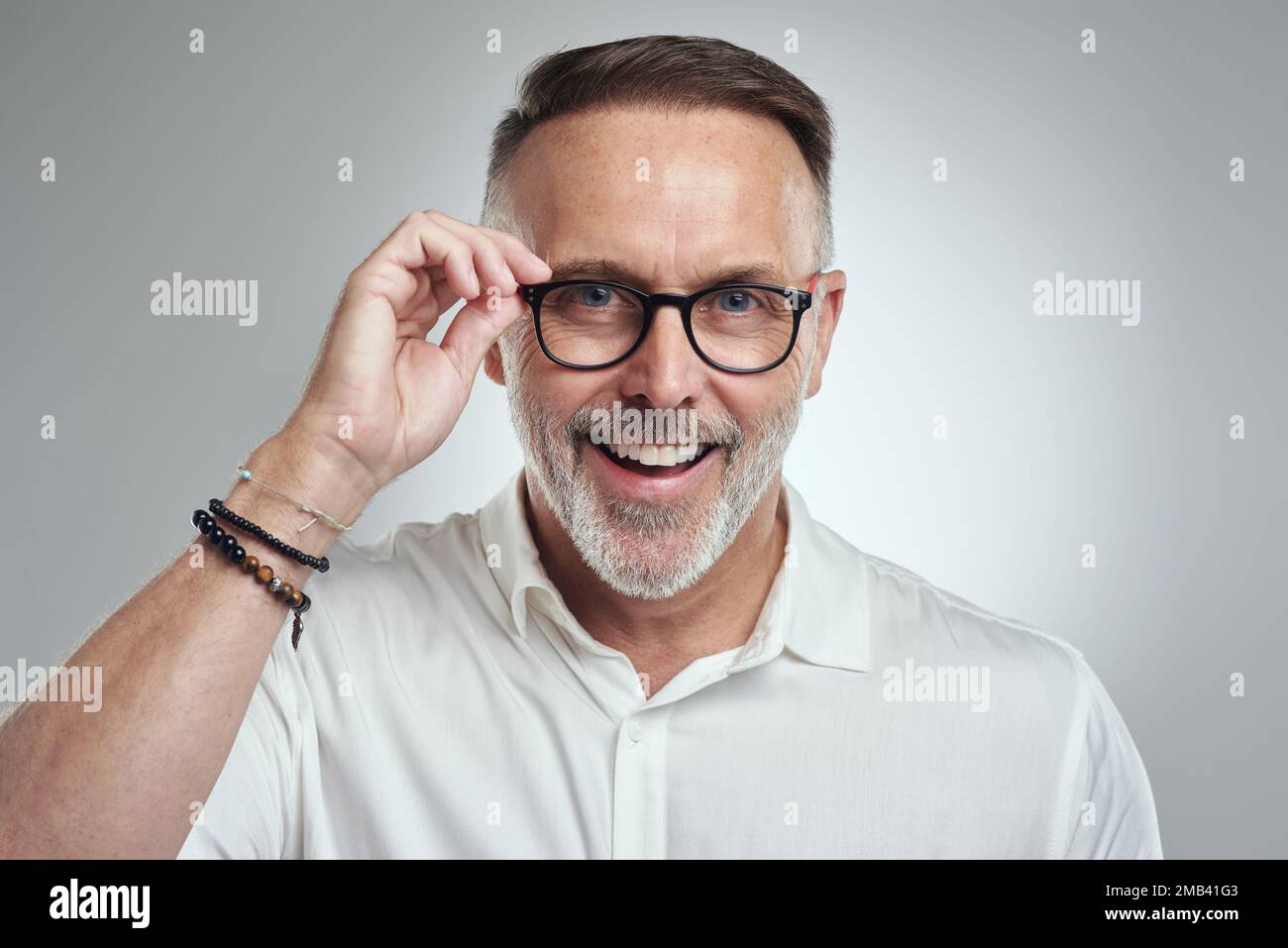 Spero a Ci vediamo. Ritratto di un uomo maturo che indossa occhiali su sfondo grigio. Foto Stock