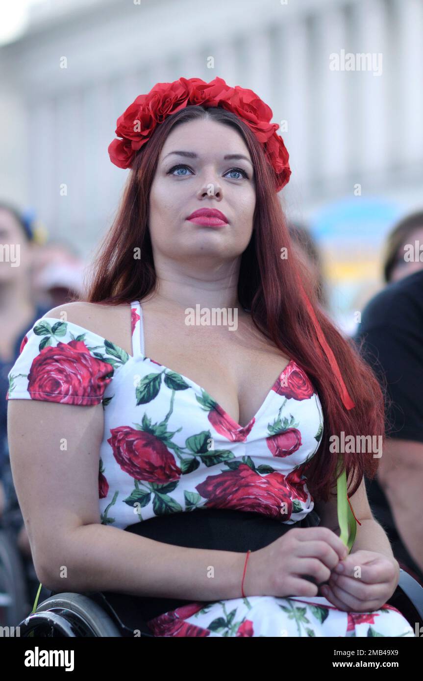 Donna con esigenze speciali, in ucraino circlet rosso nativo di fiori seduti tra il gruppo di disabili in una sedia a rotelle. Giorno dell'indipendenza del Regno Unito Foto Stock