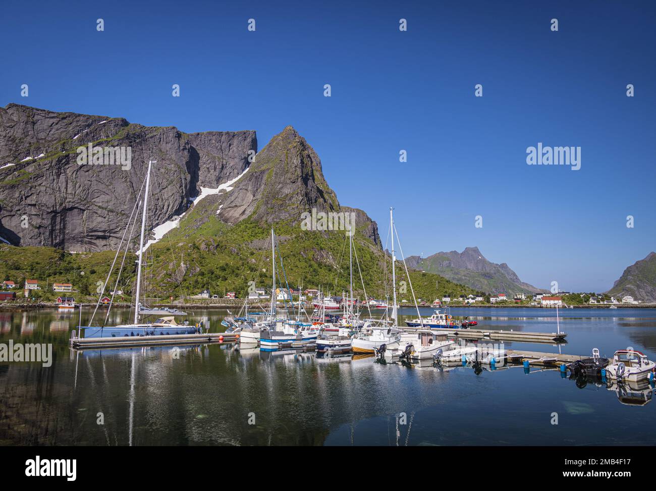 Barche nel porto di Reine, e montagne, Moskenesoya, Isole Lofoten, Nordland, Norvegia Foto Stock