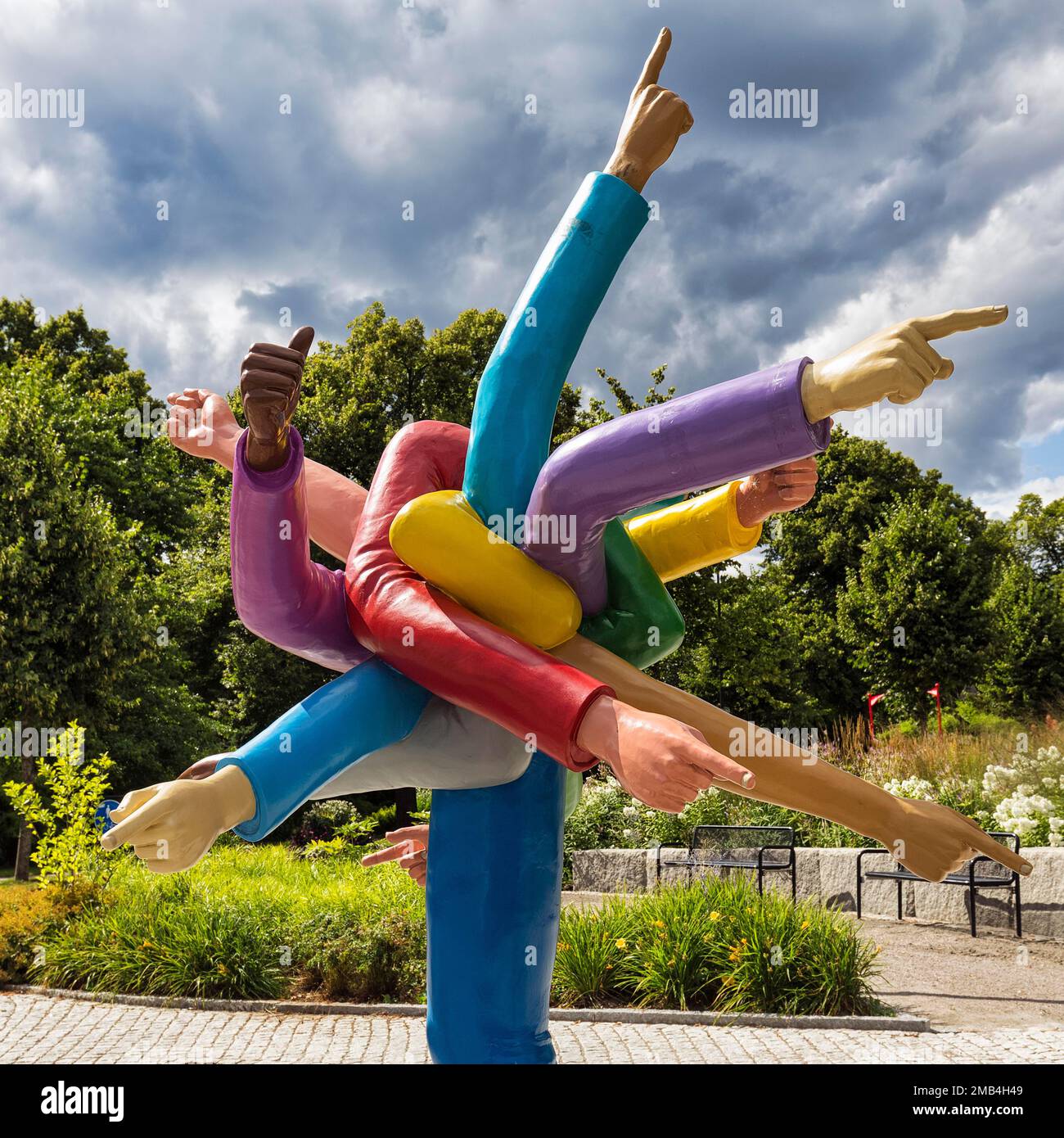 Molte braccia colorate che puntano in direzioni diverse con il dito indice allungato, divertente scultura fatta di plastica sul lato della strada, simbolo di Foto Stock