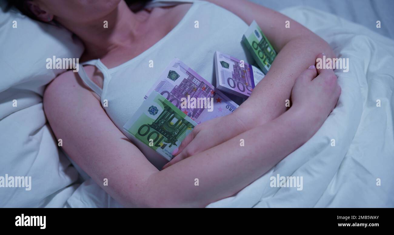 Donna che dorme sul letto con il pacchetto delle note di valuta Foto Stock