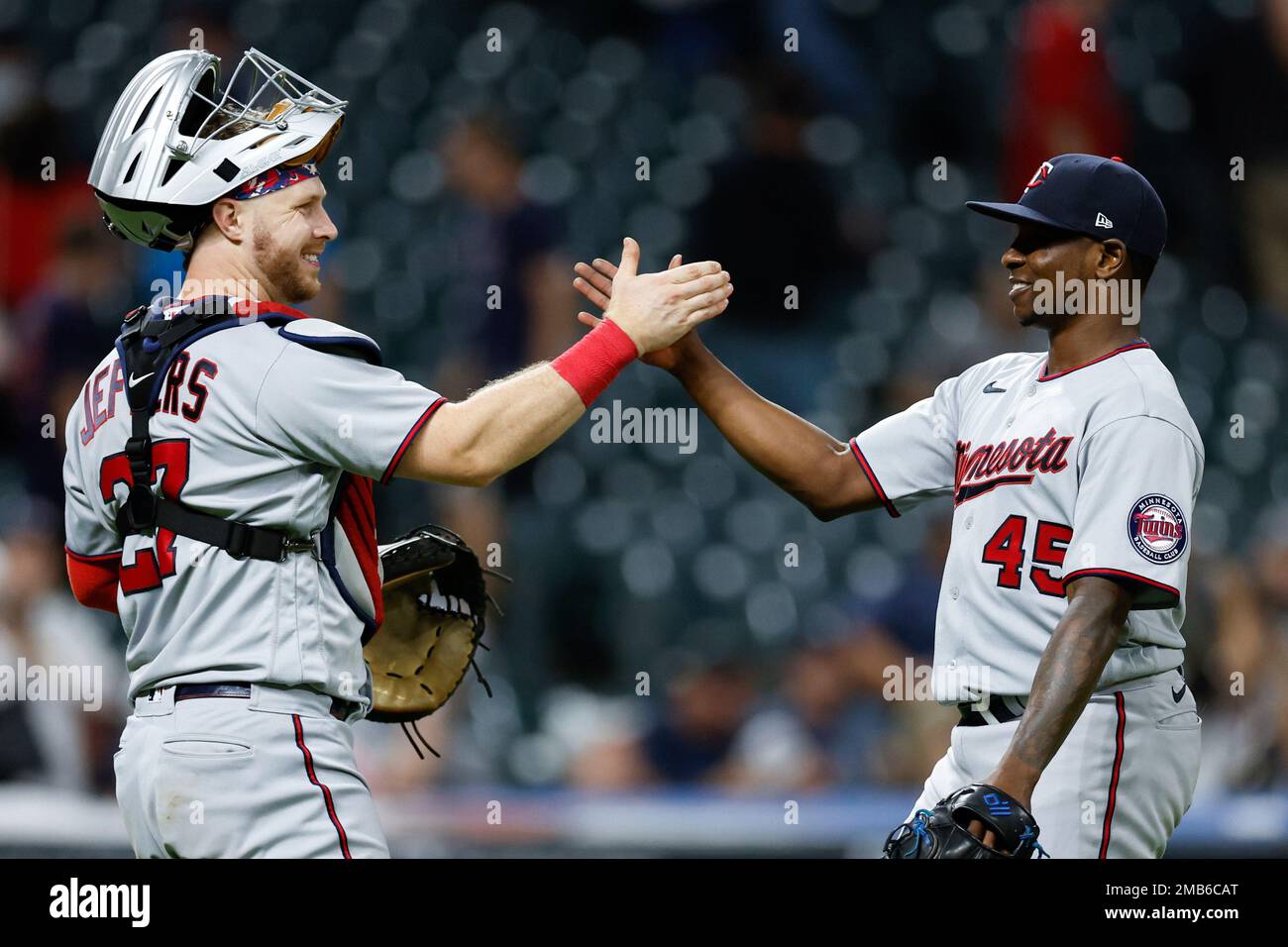Minnesota Twins relief pitcher Jharel Cotton (45) and catcher Ryan Jeffers (27) celebrate a win over the Cleveland Guardians in a baseball game Monday, June 27, 2022, in Cleveland. (AP Photo/Ron Schwane) Foto Stock