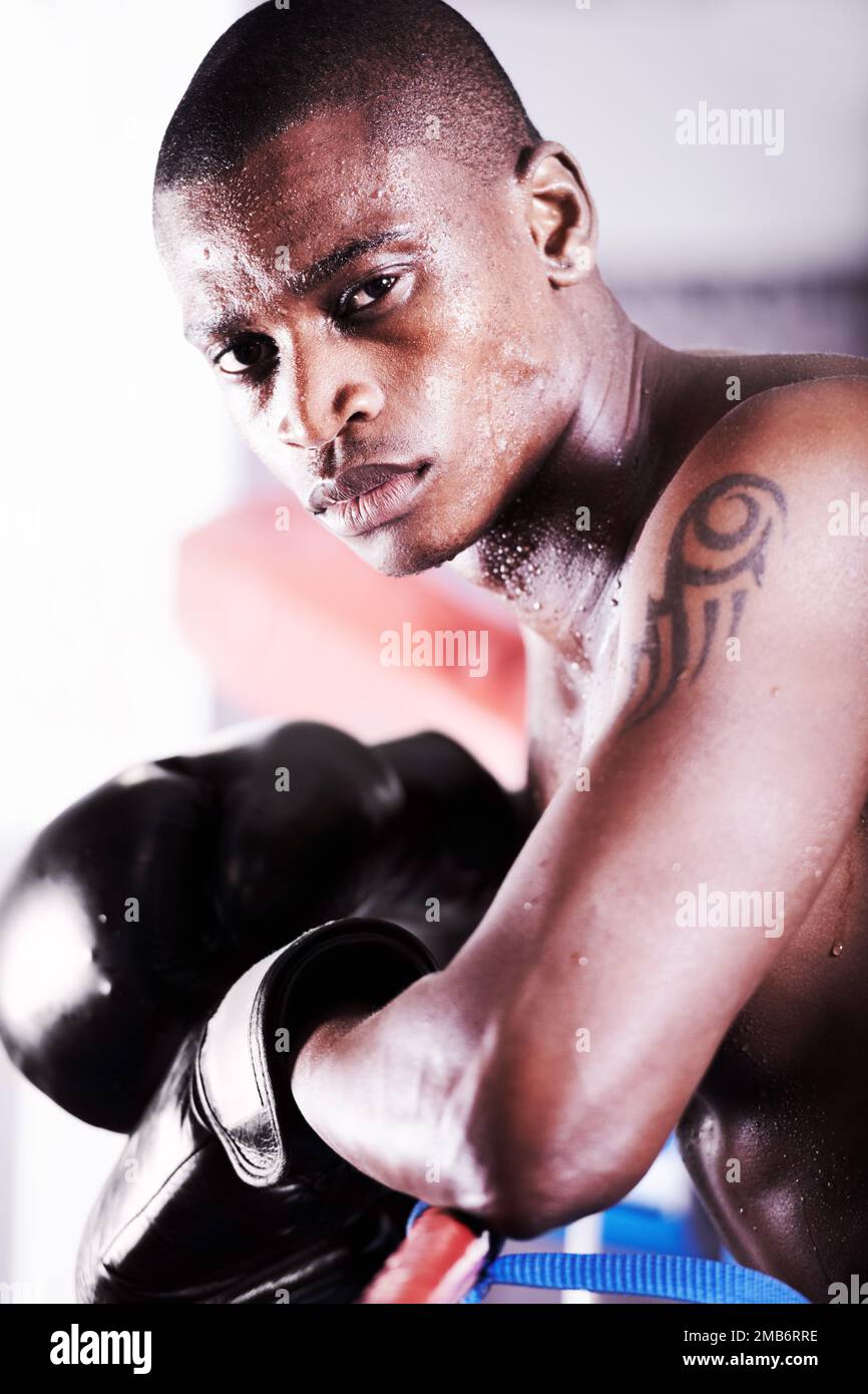 Questa è la mia passione e questa è la mia vita. Un pugile afroamericano appoggiato sulle corde e guardandovi con determinazione. Foto Stock