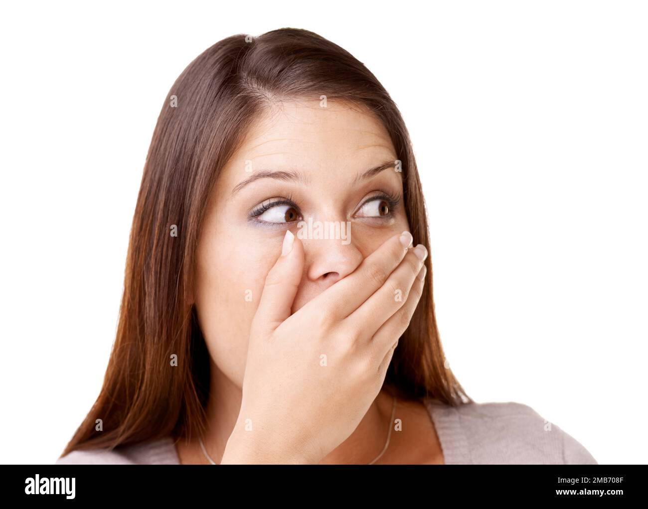 Non avrei mai detto nulla...sorpresa giovane donna che copriva la bocca su uno sfondo bianco. Foto Stock
