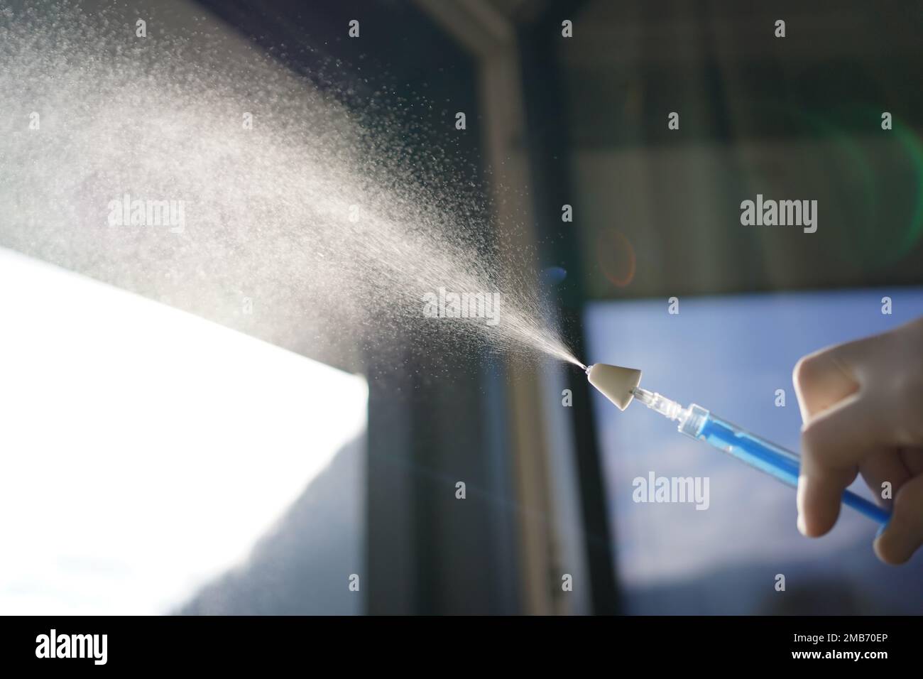 Nebulizzazione di un farmaco per applicazione intranasale con un dispositivo di nebulizzazione mucosale su una siringa. Foto Stock