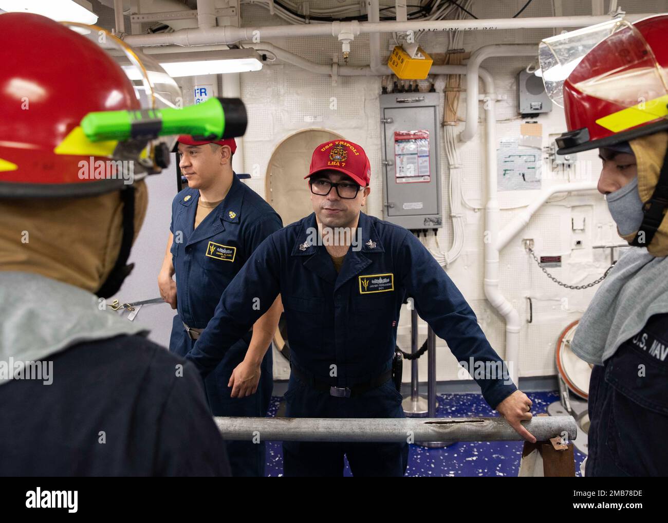 220613-N-TT639-1153 MARE DELLE FILIPPINE (13 giugno 2022) – Damage Controlman 1st Classe Javier Fernandez, da Cathedral City, California, centro, conduce un addestramento di pipe-patching durante una trivella di controllo dei danni a bordo di un carrier d'assalto anfibio USS Tripoli (LHA 7), 13 giugno 2022. Tripoli opera nell'area delle operazioni della flotta 7th degli Stati Uniti per migliorare l'interoperabilità con alleati e partner e fungere da pronta forza di risposta per difendere la pace e mantenere la stabilità nella regione dell'Indo-Pacifico. Foto Stock