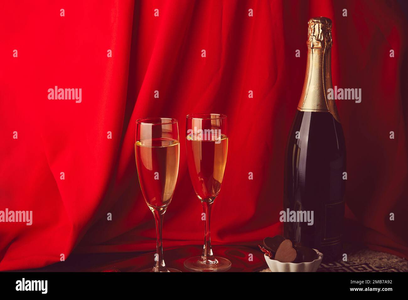 Cibo tradizionale di San Valentino sfondo. Romantico champagne rosso di stagione e caramelle al cioccolato. Spazio di copia. Foto Stock