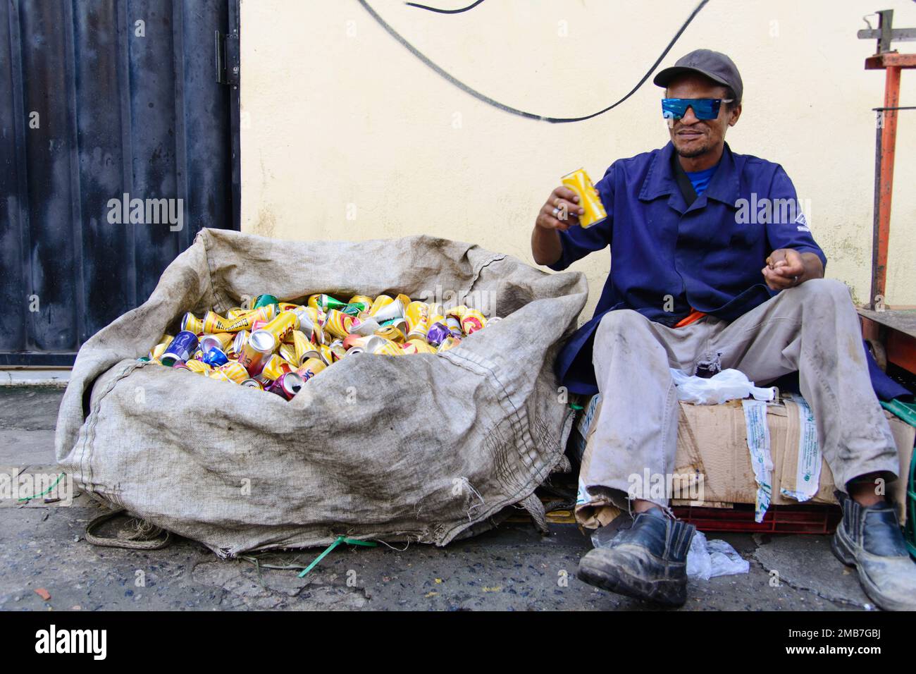 Salvador, Bahia, Brasile - 09 febbraio 2018: Può picker riposo seduto dopo il lavoro nella notte di Carnevale nella città di Salvador, Bahia. Foto Stock