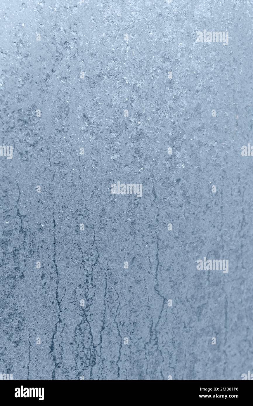 Finestra congelata, disegno di ghiaccio sul vetro in inverno freddo. Consistenza del ghiaccio Foto Stock