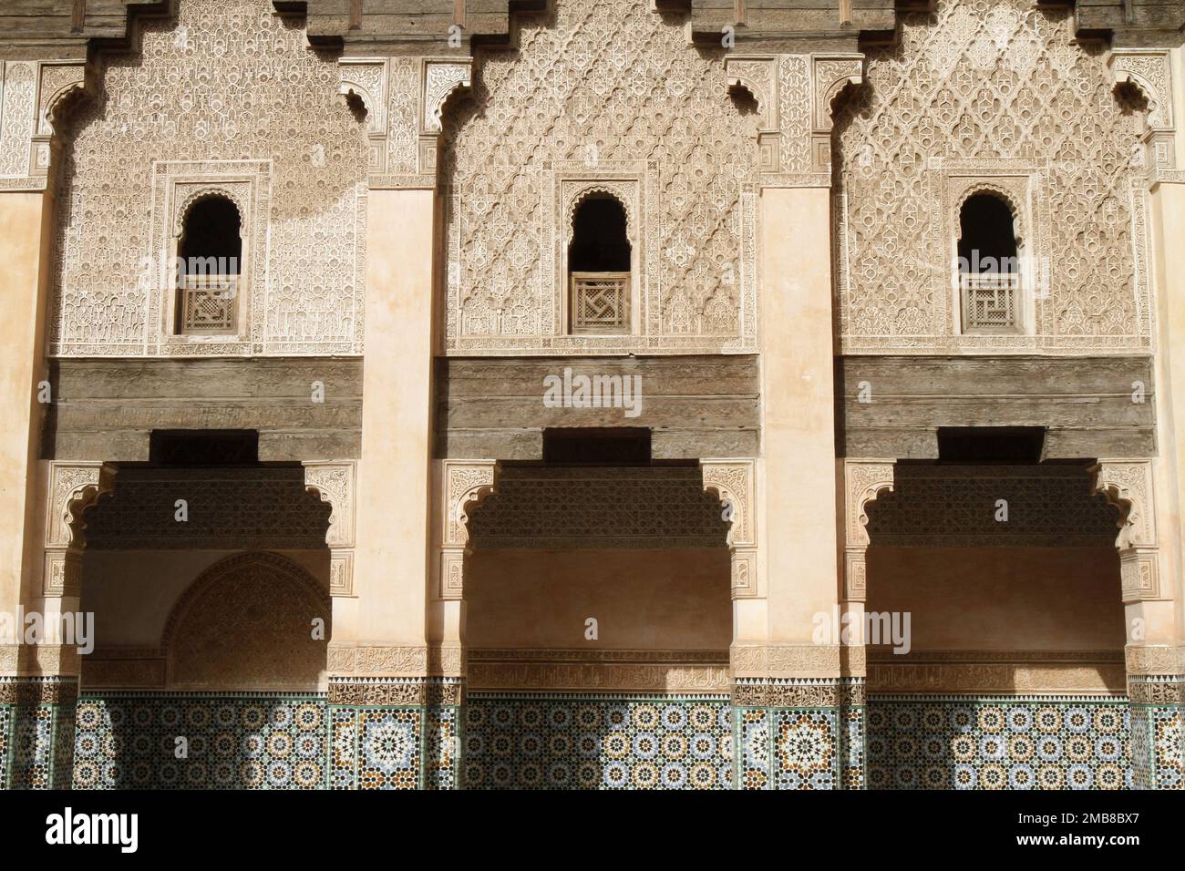 Zelliges et stuc sculpté. Medersa ben Youssef, école coranique fondée par le Sultan mérinide Abu al-Hassan. 1570. Marrakech. Maroc. / Zelliges e auto Foto Stock