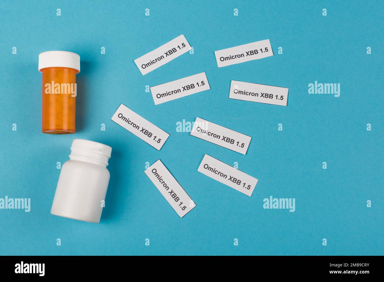 Vista dall'alto di pillole e scritta omicron xbb su sfondo blu, immagine stock Foto Stock