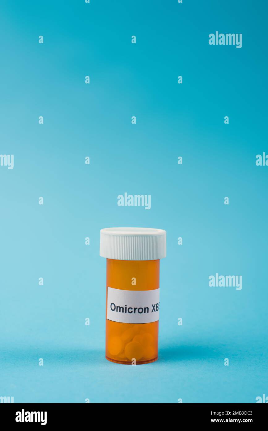 Vasetto con pillole e scritta omicron xbb su sfondo blu, immagine stock Foto Stock