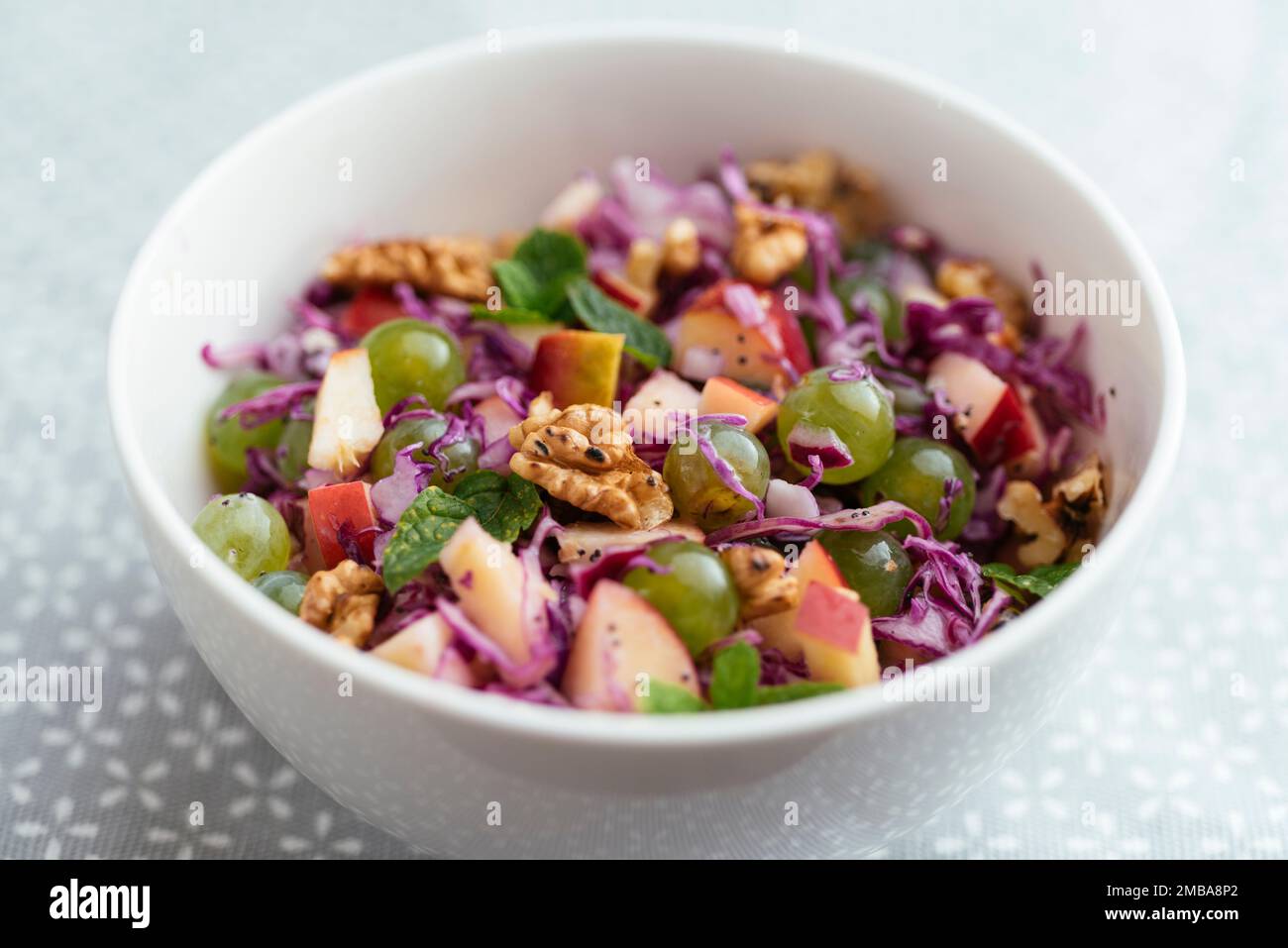 Insalata di cavolo rosso waldorf in una ciotola con un minty medicazione di semi di papavero Foto Stock