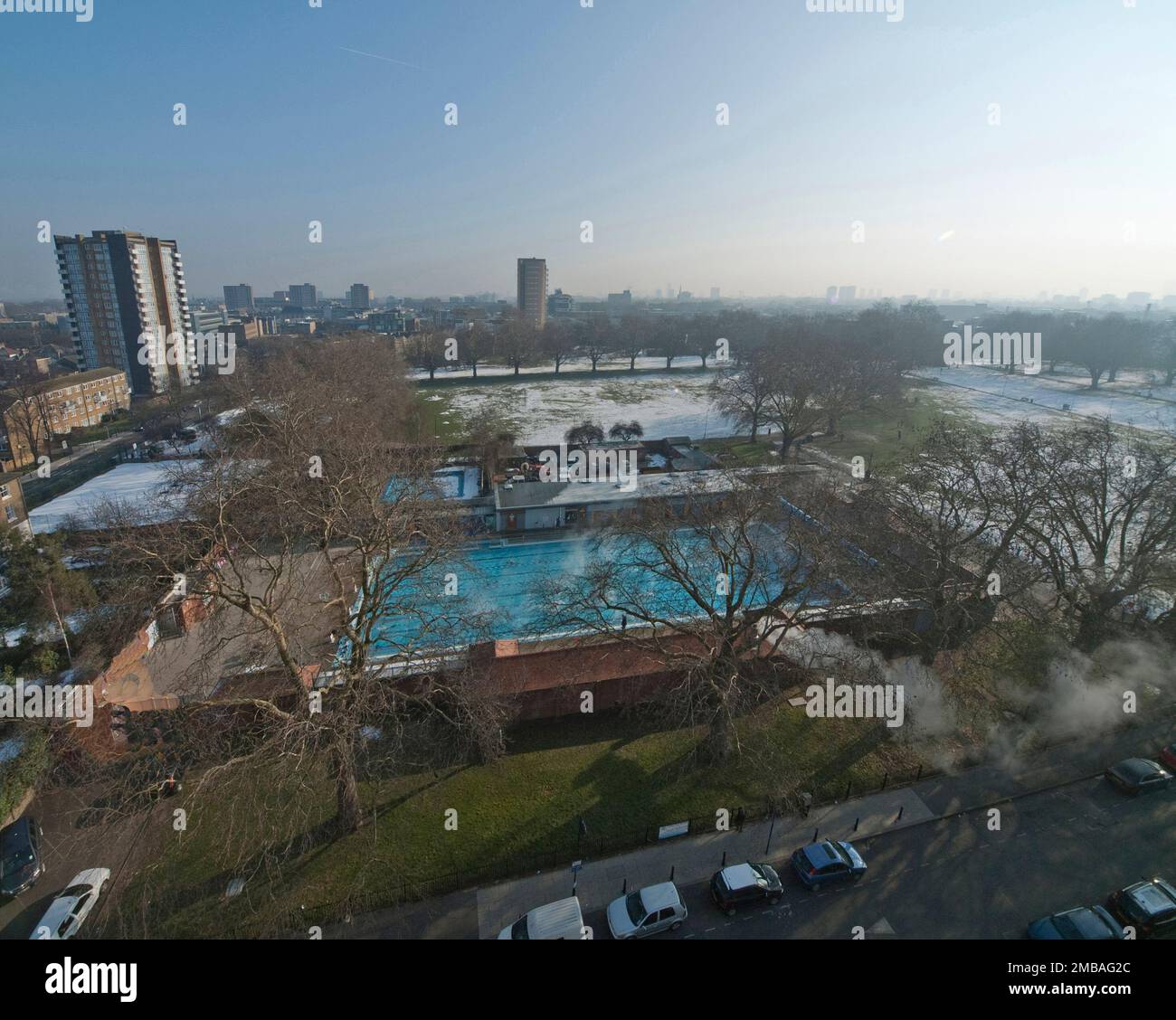 London Fields Lido, London Fields West Side, Hackney, Hackney, Greater London Authority, 2006. Una vista elevata del Lido di Londra Fields, Hackney, visto da ovest, con il vapore che sale dall'acqua e la neve che copre il parco circostante. Il London Fields Lido è stato inaugurato nel 1932 ed è stata la seconda piscina all'aperto ad essere aperta dal London County Council. Chiuse nel 1988 e divenute derelict. Dopo &#XA3;2,5 milioni di lavori di ristrutturazione di Space &amp; Place Architects (S+P Architects), la piscina è stata riaperta nel 2006. Questa fotografia è stata probabilmente presa dal blocco torre di 1-46 Morland Estate a Londo Foto Stock