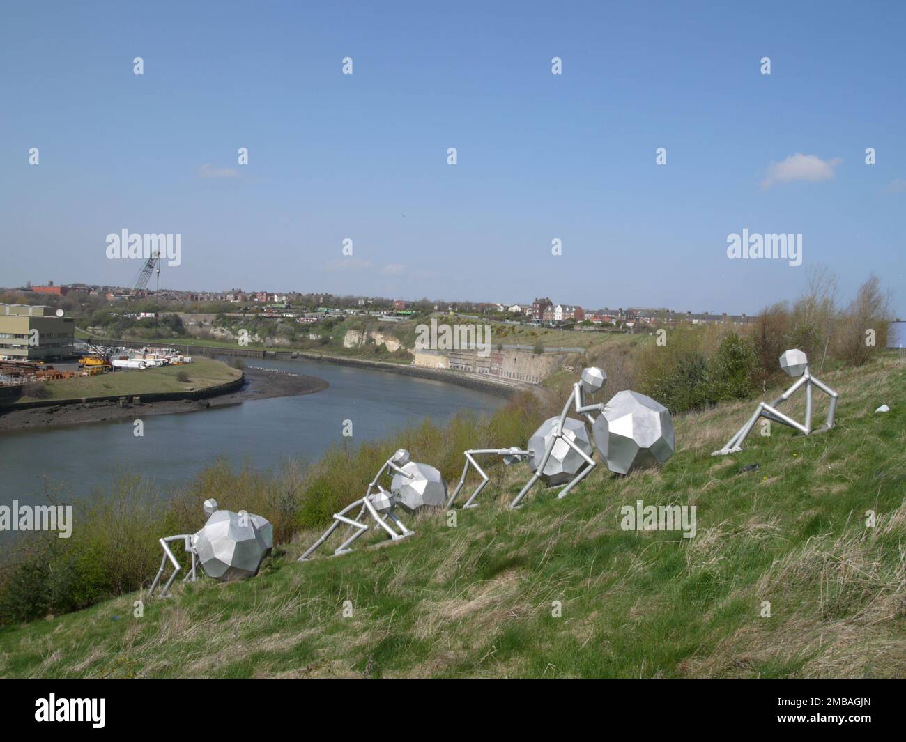 Stadium of Light, Millennium Way, Monkwearmouth, Sunderland, 2010. La scultura "uomini d'acciaio" di Graeme Hopper, sul pendio erboso tra il Fiume Wear e lo Stadio della luce, Sunderland, con il fiume oltre. La scultura fu installata nel 2001. E' uno dei numerosi pezzi d'arte pubblica situati intorno al complesso dello stadio. Foto Stock