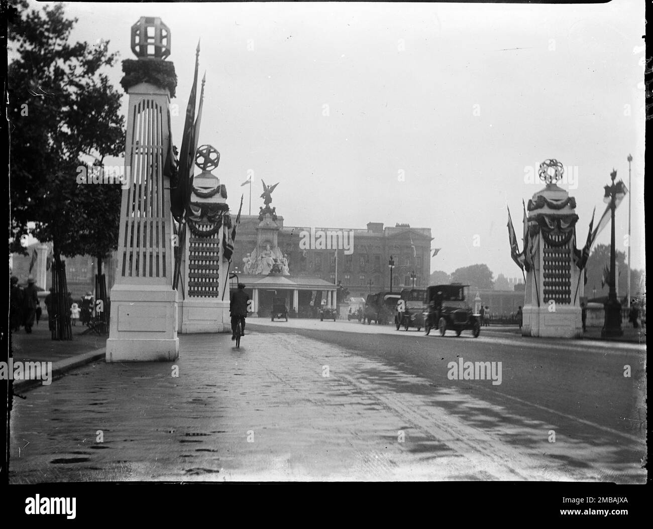 The Mall, City of Westminster, Greater London Authority, 1919. Una vista lungo il Mall in direzione di Buckingham Palace, mostrando pali della bandiera e tralicci temporanei che commemorano le famose battaglie, i siegi e le liberazioni della prima guerra mondiale Al centro si trova il King's Stand eretto intorno al Queen Victoria Memorial. Questa fotografia fa parte di un gruppo che il fotografo ha preso sul 18th, 21st &amp; 23rd luglio 1919 registrando le decorazioni di pace che erano state erette a Londra per la Giornata della Pace e la Vittoria marzo, 19th luglio 1919, in celebrazione della fine della guerra mondiale 1. Foto Stock