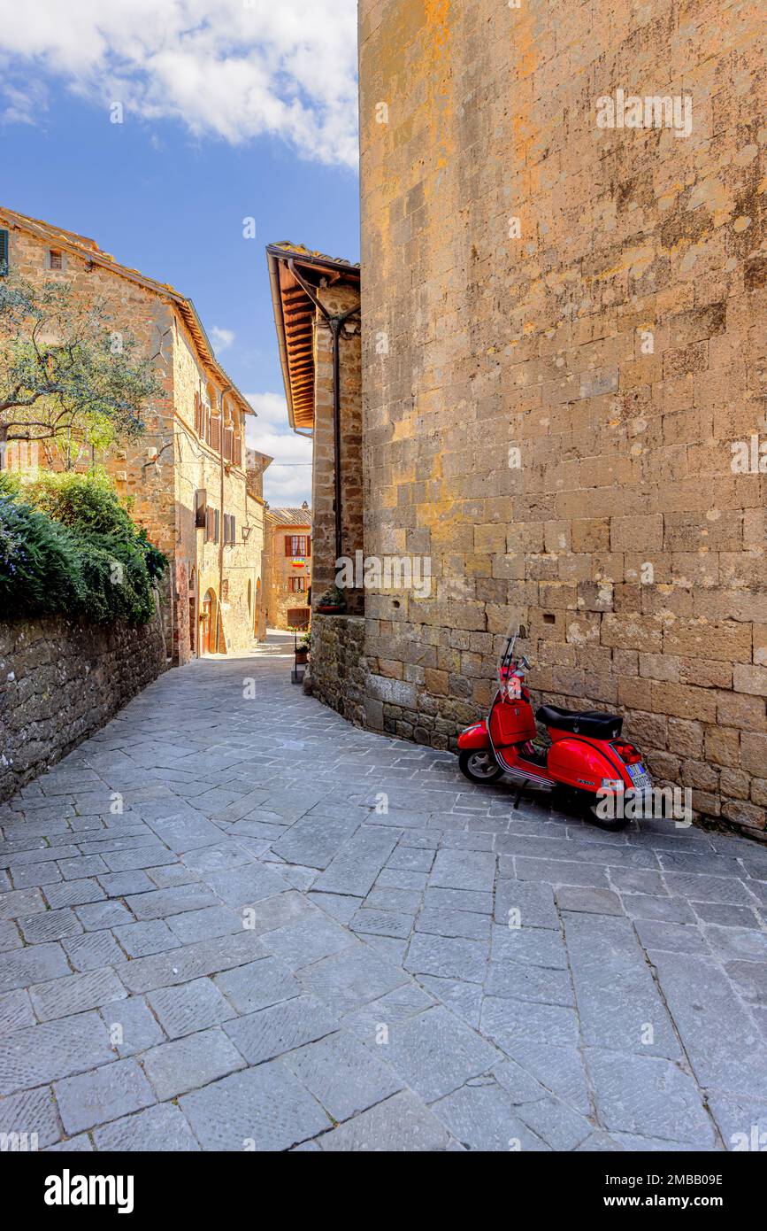 Scooter rosso per le strade di Montichiello in Val d'Orcia in Toscana. Foto Stock