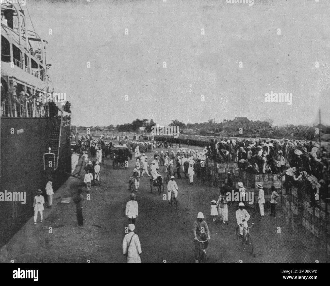 «Le Periple des Russes : De Moscou a Marseille par la Siberie, les Mers de Chine et des Indes et le Canal de Suez; Escale a Saigon (8 Mars) : Colons et indienes sur le quai : au fond, les troupes alignees», 1916. Da "Collection de la Guerre IV. L'Illustrazione Tome CXLVII. La Guerre Janvier, Fevrier, Mars, Avril, mai, Juin 1916". Foto Stock