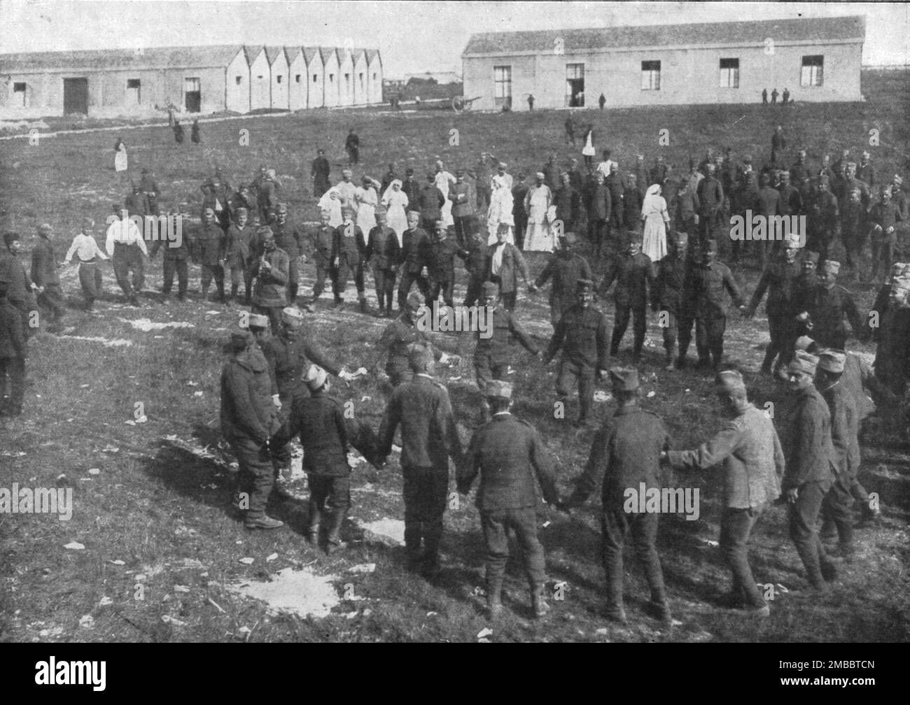 'Les hotes de la Tunisie; contents Serbes et prigionniers allemands : les jeunes soldats, soignes a l'hopital de Sidi Fath Allah, pres de Tunis, ont retrouve leur vigueur et se divertissent en dansant, devant leurs infirmeres, leurs danses nazionales', 1916. Da "Collection de la Guerre IV. L'Illustrazione Tome CXLVII. La Guerre Janvier, Fevrier, Mars, Avril, mai, Juin 1916". Foto Stock