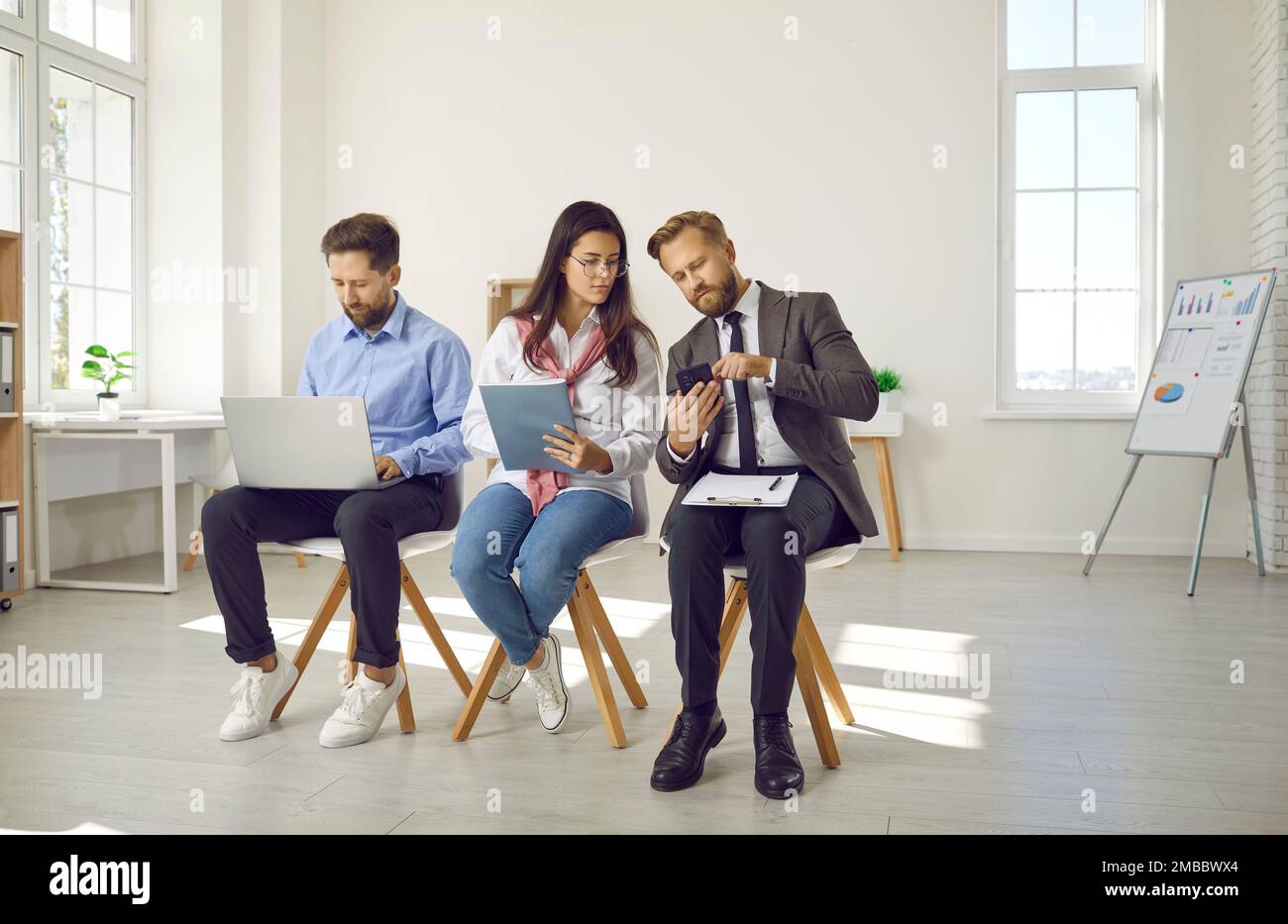Uomini d'affari in attesa di un colloquio di lavoro, vista frontale Foto Stock