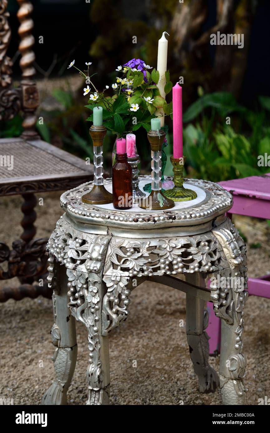 Tavolo ornato, piccolo tavolo rotondo, giardino design, tavolo rotondo riempito con candele, tavolo con candele, giardino all'aperto design, RM Floral Foto Stock