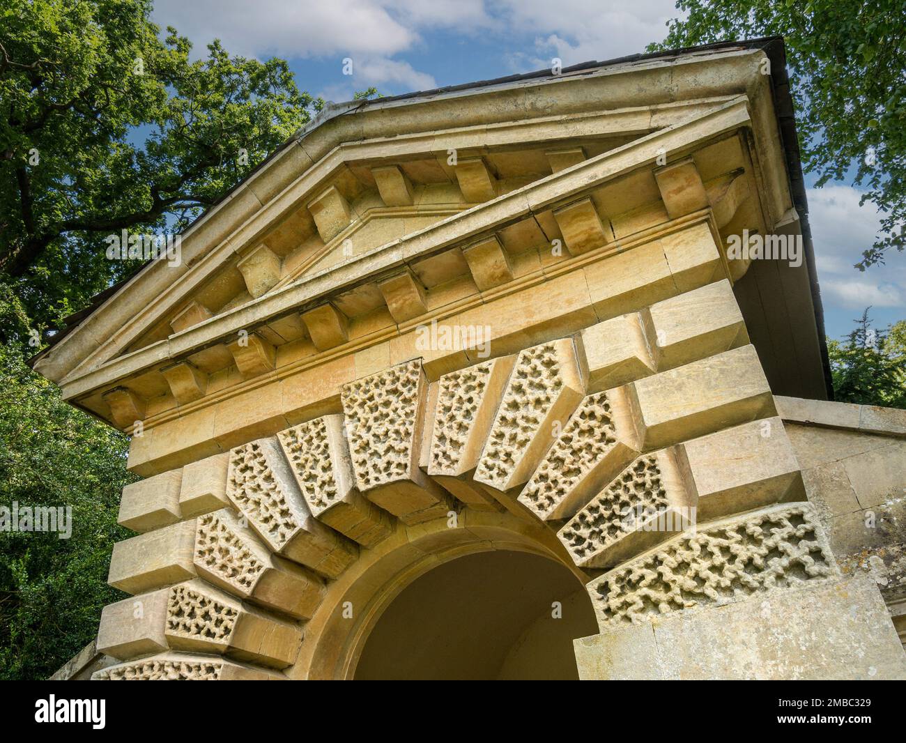 Arco rusticato e frontone dentilato del C18 Palladiano Garden Temple a Belton House Gardens, Lincolnshire, Inghilterra, Regno Unito Foto Stock