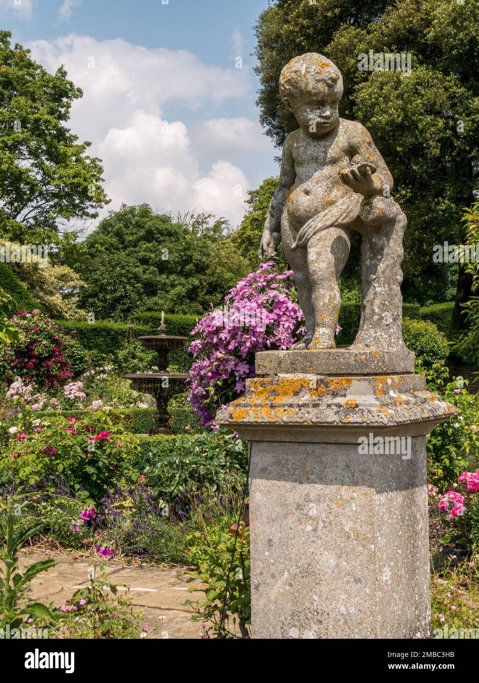 Statua ornamentale di cherubini in pietra nel giardino delle rose al castello di Belvoir, Leicestershire, Inghilterra, Regno Unito Foto Stock