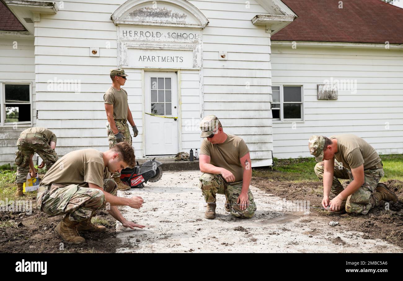 I soldati della Guardia Nazionale dell'Esercito Iowa assegnati alla 831st Engineer Company segnano una linea retta con filo sul cemento appena versato presso la storica Herrold School House nell'area di addestramento di Camp Dodge a Johnston, Iowa, il 14 giugno 2022. La CE del 831st è stata incaricata di completare vari progetti intorno a Camp Dodge. Sono stati apportati degli aggiornamenti alla scuola per consentire ai soldati di utilizzare la scuola come centro operativo tattico. Sarà possibile configurare le proprie comunicazioni wireless per simulare un centro operativo temporaneo durante il conflitto. Foto Stock