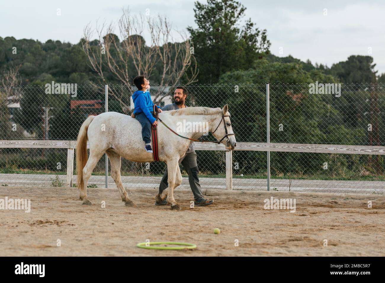 Ragazzo felice con disabilità che si diverte durante la terapia equina Foto Stock