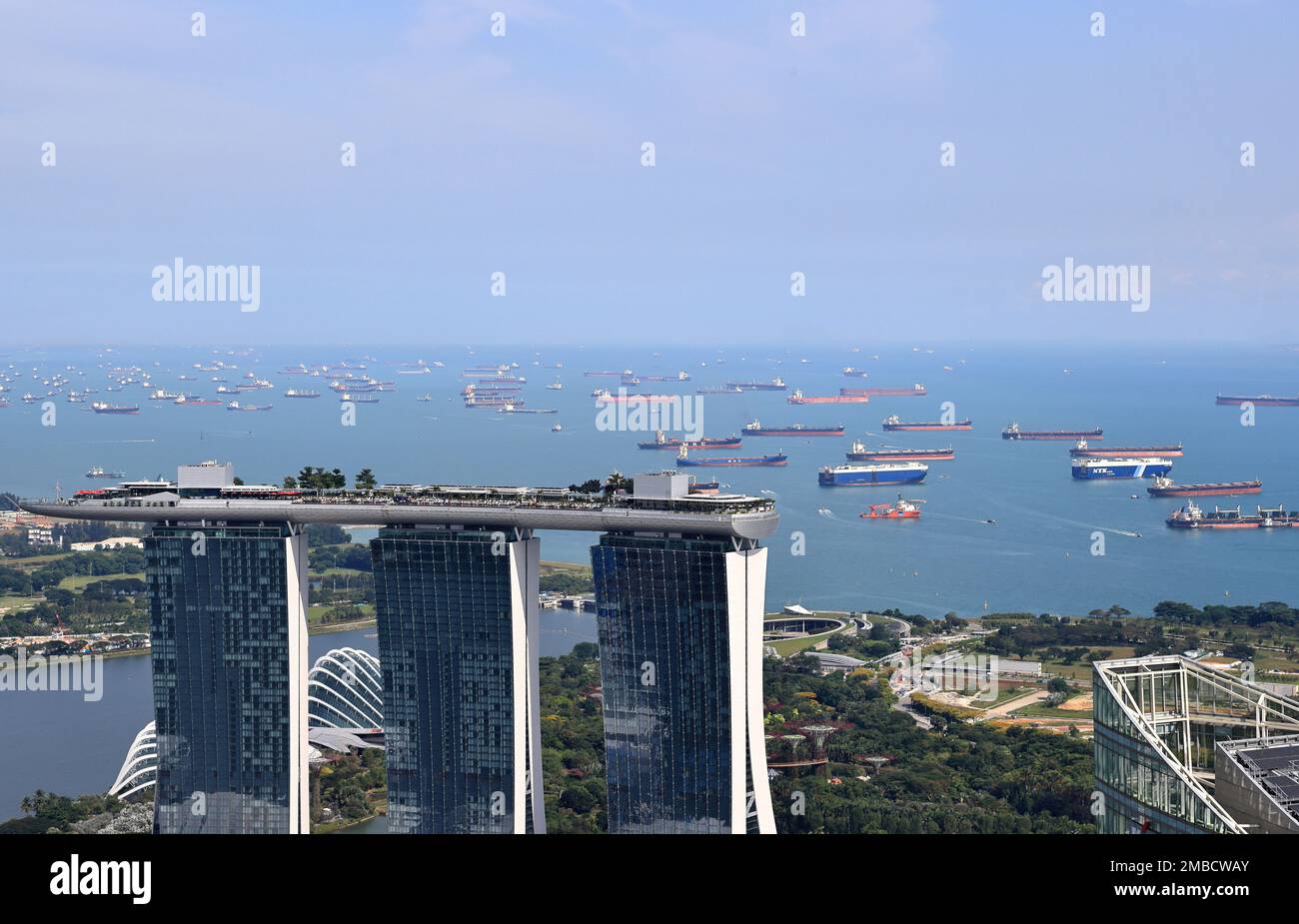 Vista aerea del transatlantico e della nave da carico nello stretto di Singapore come sfondo dell'edificio di Marina Bay Sands Singapore. Foto Stock