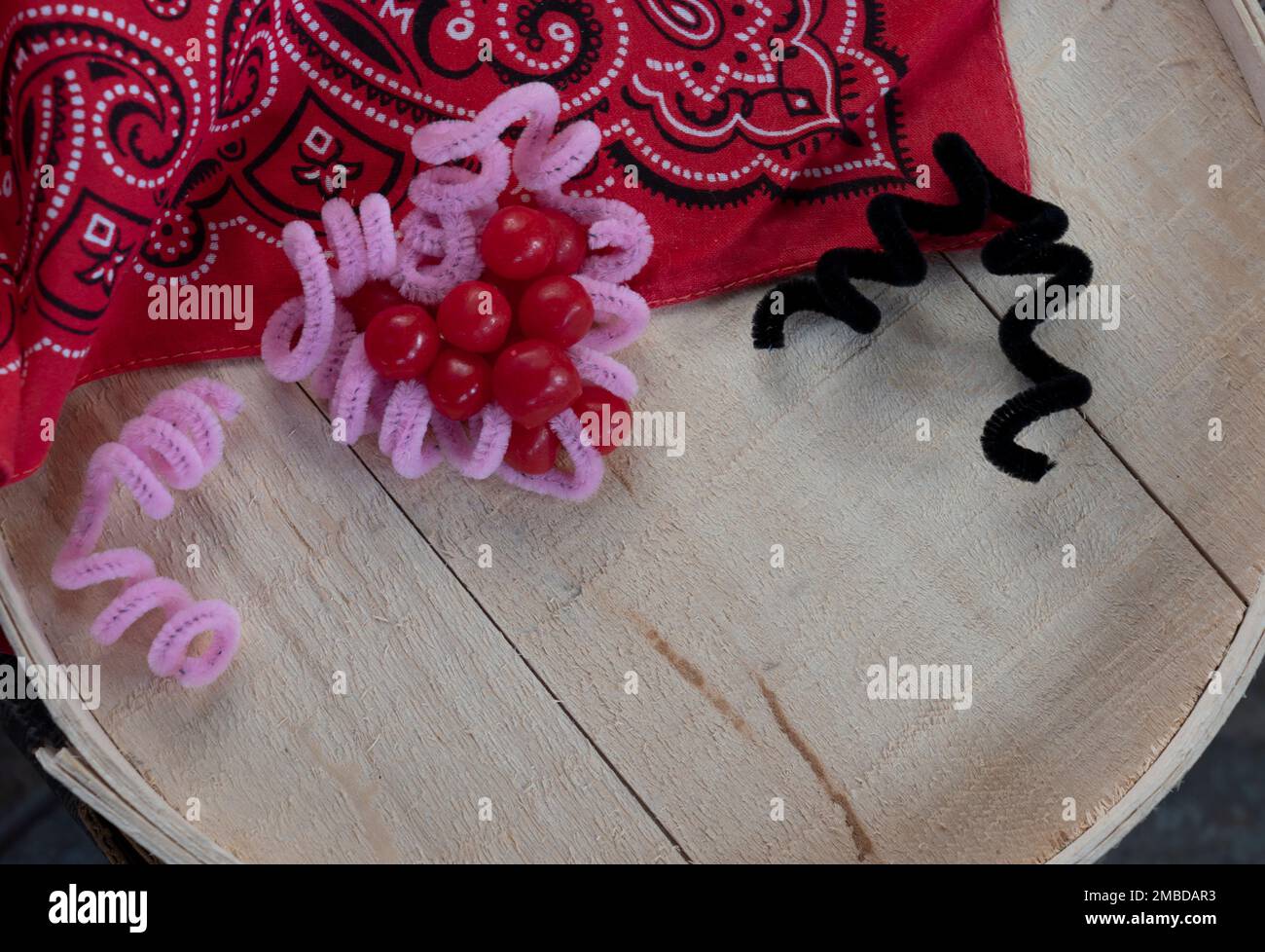 Cuore con dolci è circondato da bandana rossa e cowboy e cowgirl indicato da forme più pulite tubo. Spazio di testo disponibile su sfondo in legno. Foto Stock