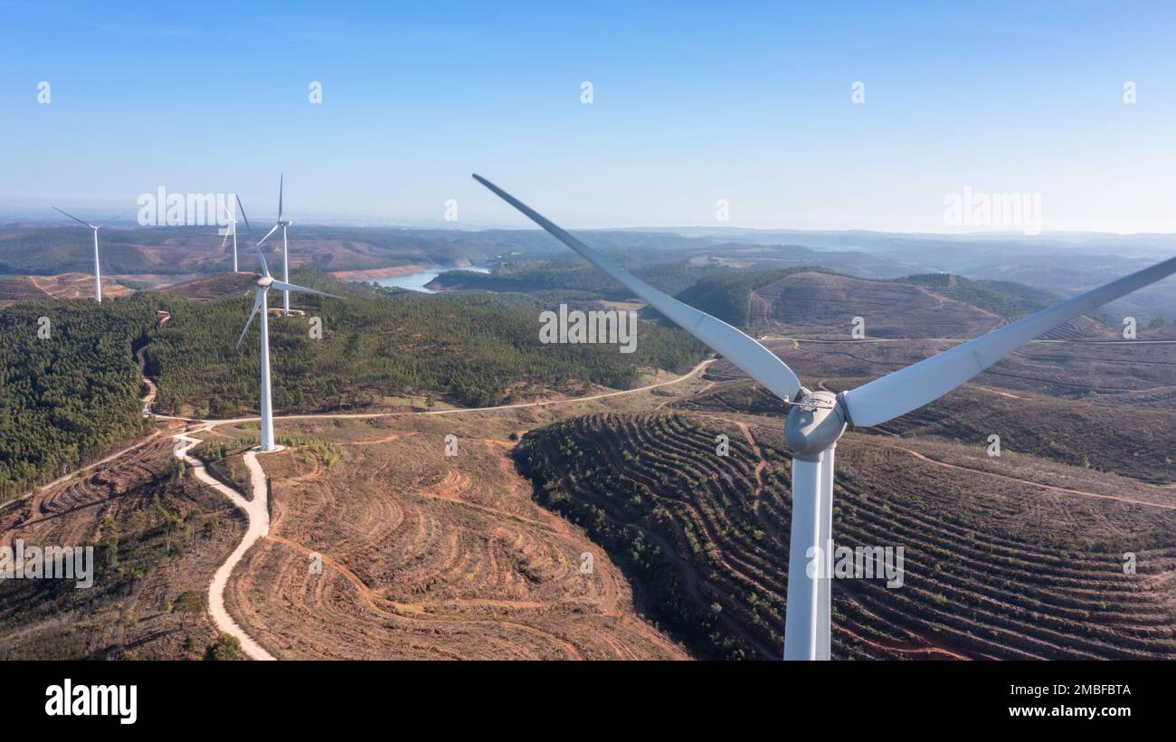 Le turbine eoliche generano elettricità pulita e verde nei campi del Portogallo. Con vista sulla diga di Bravura. Foto Stock