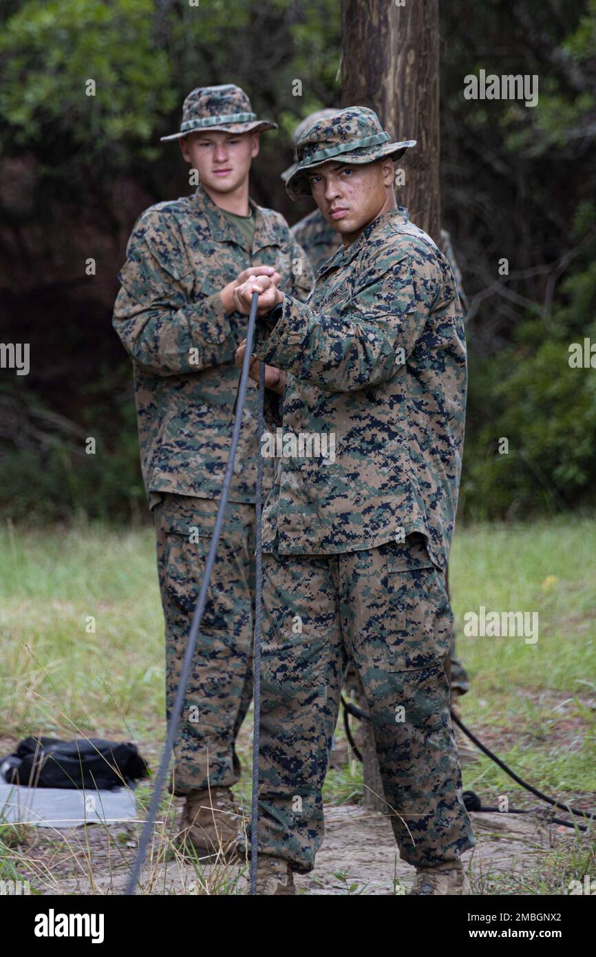 STATI UNITI Marine Corps PFC Michael Estur e PFC Nicholas Oriole, con Marine Corps Engineer School, stringono una corda di sicurezza mentre allestisce un ponte di corda, il 29 giugno 2022 a Camp Lejeune, NC. La Marine Corps Engineer School insegna ai Combat Engineers queste abilità per le operazioni future per poter superare lacune, flussi e fiumi per garantire il successo della missione. Foto Stock