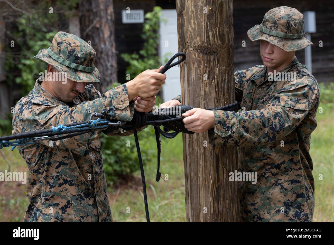 STATI UNITI Marine Corps PFC Nicholas Cervera e PFC Damian Shifflett, con Marine Corps Engineer School, hanno istituito un attacco di attrito durante la costruzione di un ponte di corda, 29 giugno 2022 a Camp Lejeune, NC. La Marine Corps Engineer School offre programmi di formazione dedicati agli ingegneri approvati a livello di ingresso e supervisione per preparare gli ingegneri del corpo marino al lavoro con la Fleet Marine Force. Foto Stock