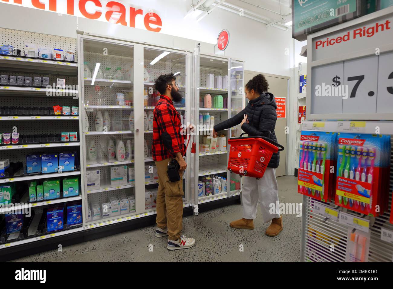 Un lavoratore del negozio al dettaglio sblocca un armadio antifurto per un cliente che acquista articoli da toeletta in un negozio Target a New York. (vedi maggiori informazioni) Foto Stock