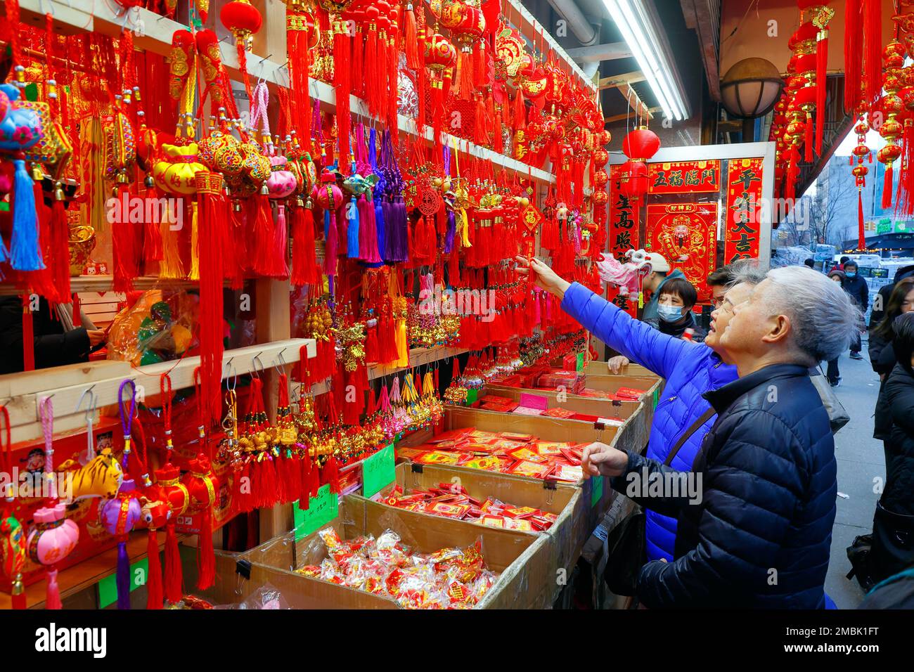 Una coppia asiatica più anziana che comprava le tessere e le decorazioni del nuovo anno lunare in un negozio a Manhattan Chinatown, New York City, 20 gennaio 2023. Foto Stock