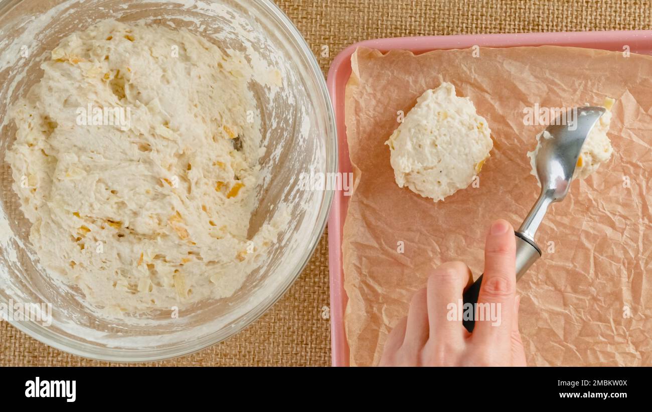 Ricetta per biscotti al formaggio, cottura. Donna che scooping biscotto daugh in una teglia da forno Foto Stock