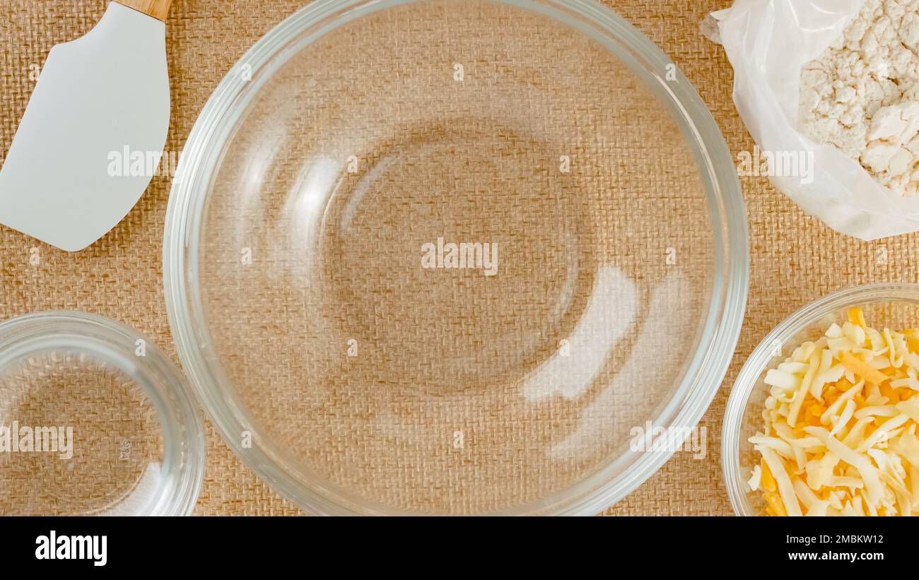 Ciotole di vetro e ingredienti per la ricetta dei biscotti al formaggio primo piano su un tavolo da cucina, vista dall'alto Foto Stock