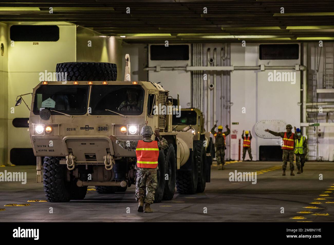 I soldati della riserva dell'esercito con la 390th Seaport Operations Company agiscono come guide di terra mentre dirigono un camion tattico di mobilità estesa pesante per parcheggiare sul ponte inferiore della MV Cape Orlando (T-AKR2044) durante un roll-on/roll-off al porto di Oakland in Oakland, California, 17 giugno 2022. Questa operazione di roll-on/roll-off è stata una parte essenziale della missione Logistics Over the Shore, che è un comandante unificato che si occupa di risorse militari e navali per schierare e sostenere una forza. Foto Stock