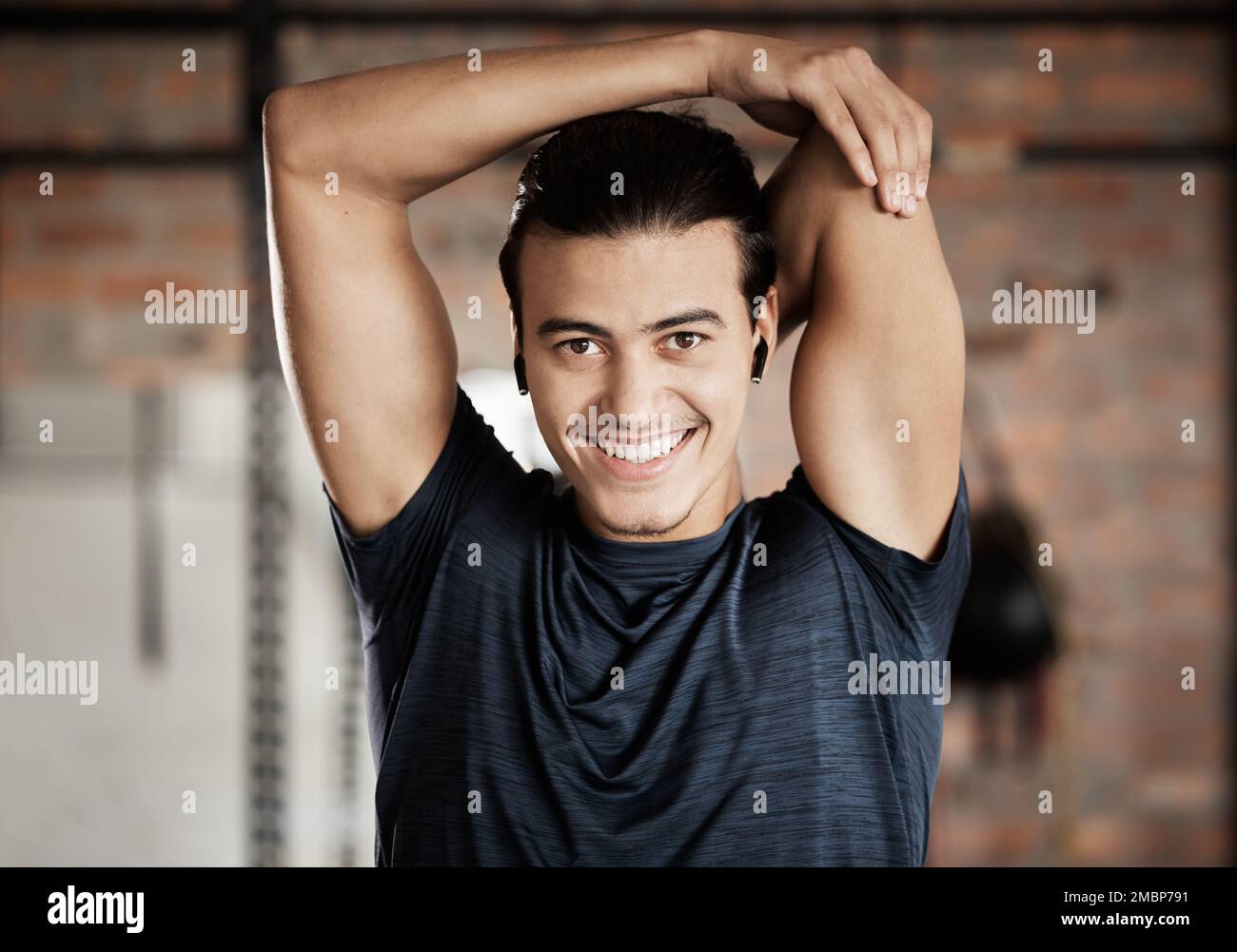 ARM stretch, fitness gym e ritratto di un uomo pronto per l'esercizio, l'allenamento e il benessere. Giovane felice, sorridente ed eccitato che sta per iniziare Foto Stock