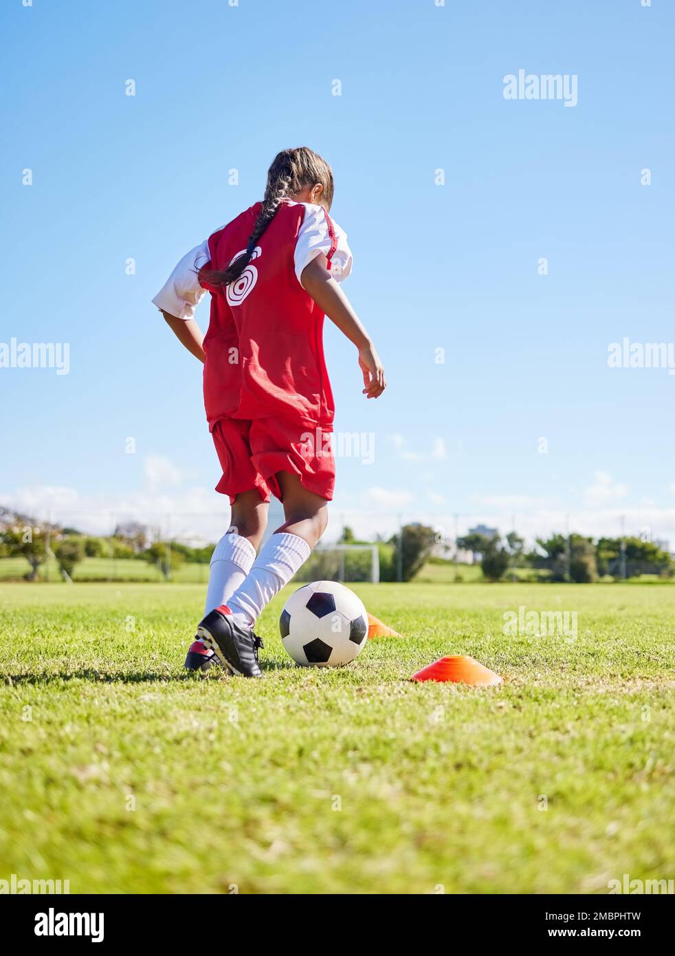 Sport, allenamento e ragazza che gioca a calcio per fitness, attività fisica e hobby su un campo in Spagna. Attivo, focus e atleta dribbling un calcio Foto Stock